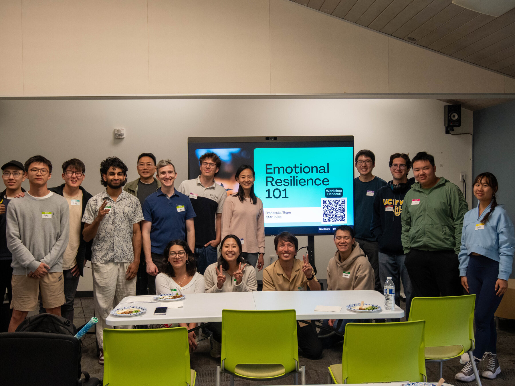 An ISMP workshop in a meeting room, the group gathered around a screen showing the session title